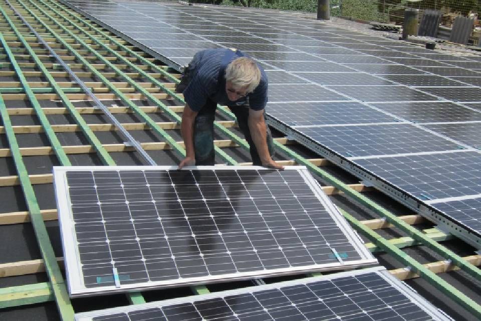 Mitarbeiter von Anton Plenkers Dachdecker- & Klempnermeister, Solarteur installiert Solaranlage