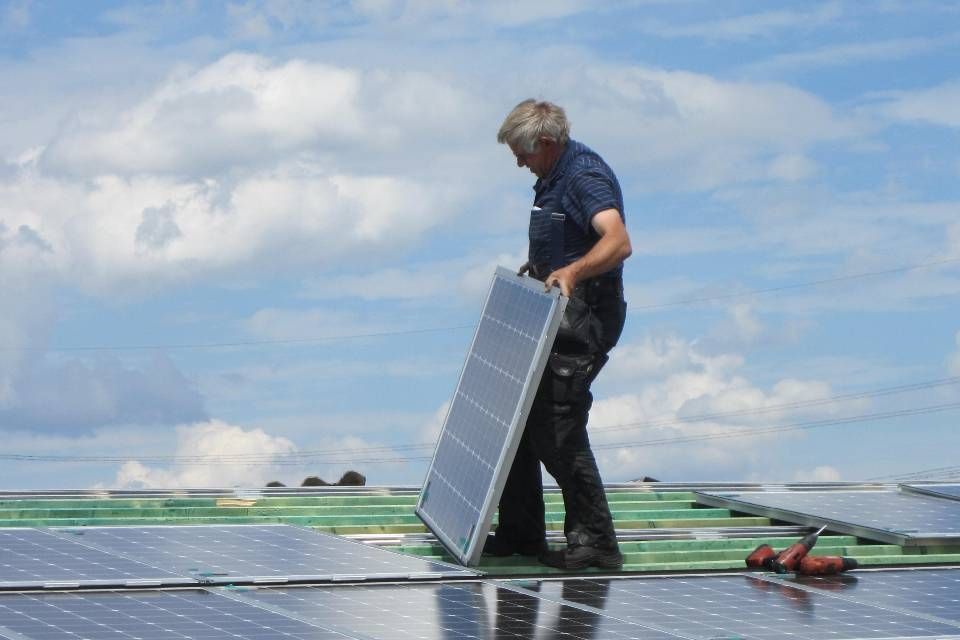Mitarbeiter von Anton Plenkers Dachdecker- & Klempnermeister, Solarteur installiert Solaranlage