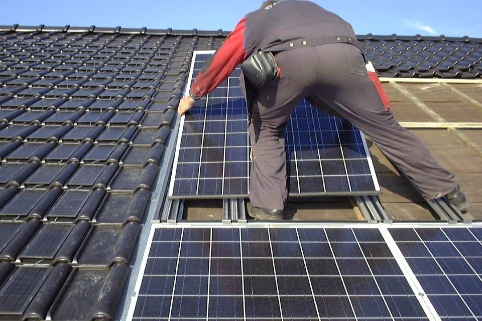 Mitarbeiter von Anton Plenkers Dachdecker- & Klempnermeister, Solarteur installiert Solaranlage