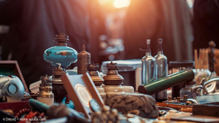 Antike Tischdekoration, verschiedene alte Lampen, Flaschen und Gegenstände; verschwommener Hintergrund.