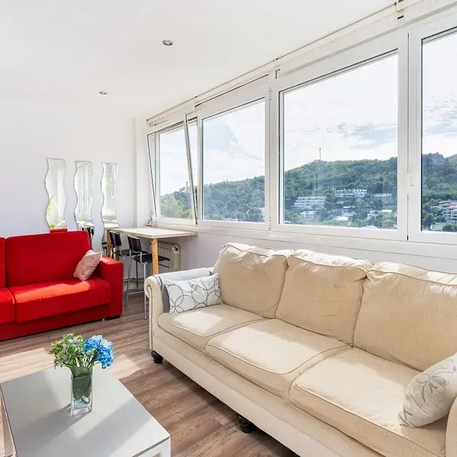 Una sala de estar con un sofá y una silla roja.