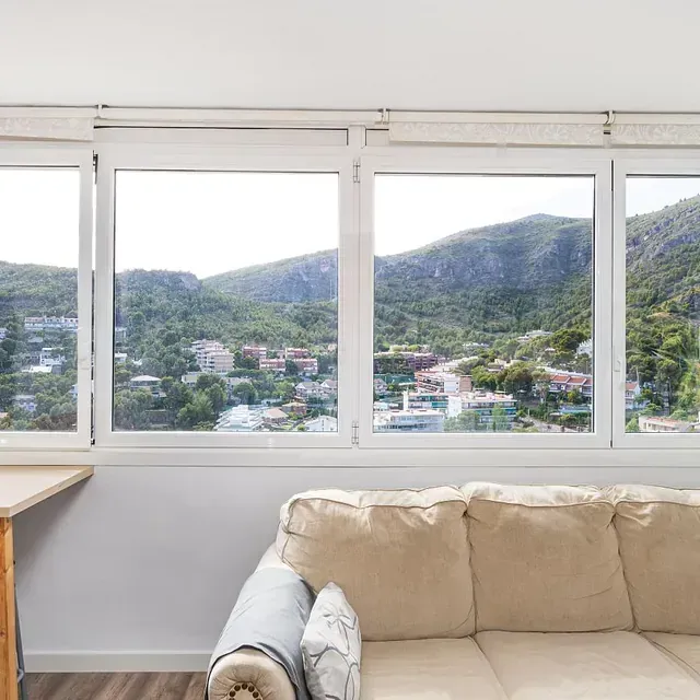 Una sala de estar con un sofá y vistas a las montañas.