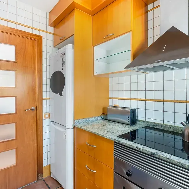 Una cocina con electrodomésticos de acero inoxidable y gabinetes de madera.
