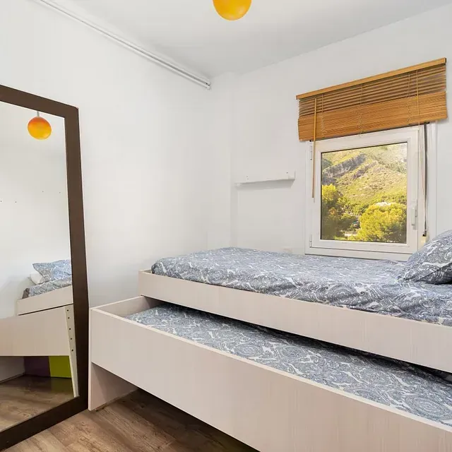 Un dormitorio con dos camas y un gran espejo.