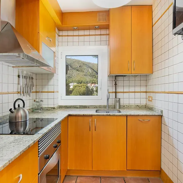 Una cocina con gabinetes de color naranja y un horno de estufa.