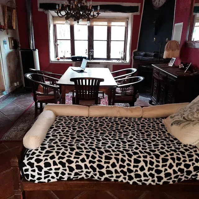 Una sala de estar con un sofá, una mesa y sillas.