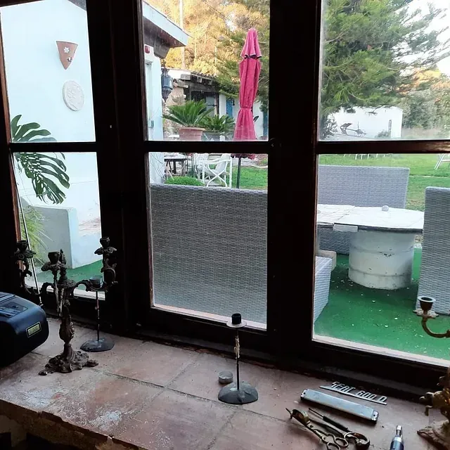 Una ventana con vista a una mesa y sillas afuera.