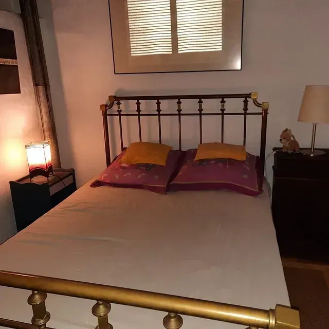 Una cama con dos almohadas y una lámpara en un dormitorio.