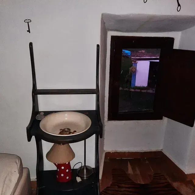 Un estante con un cuenco y una lámpara encima.