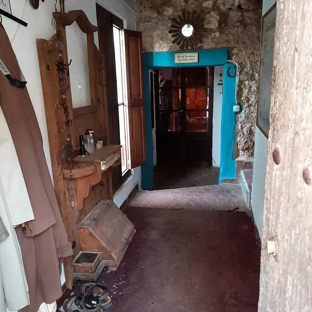 Un pasillo con una puerta azul y un espejo.