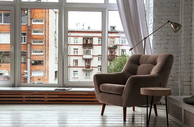 Una silla está colocada delante de una ventana grande en una sala de estar.