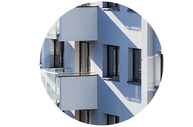 Un edificio azul y blanco con balcones y ventanas en círculo.