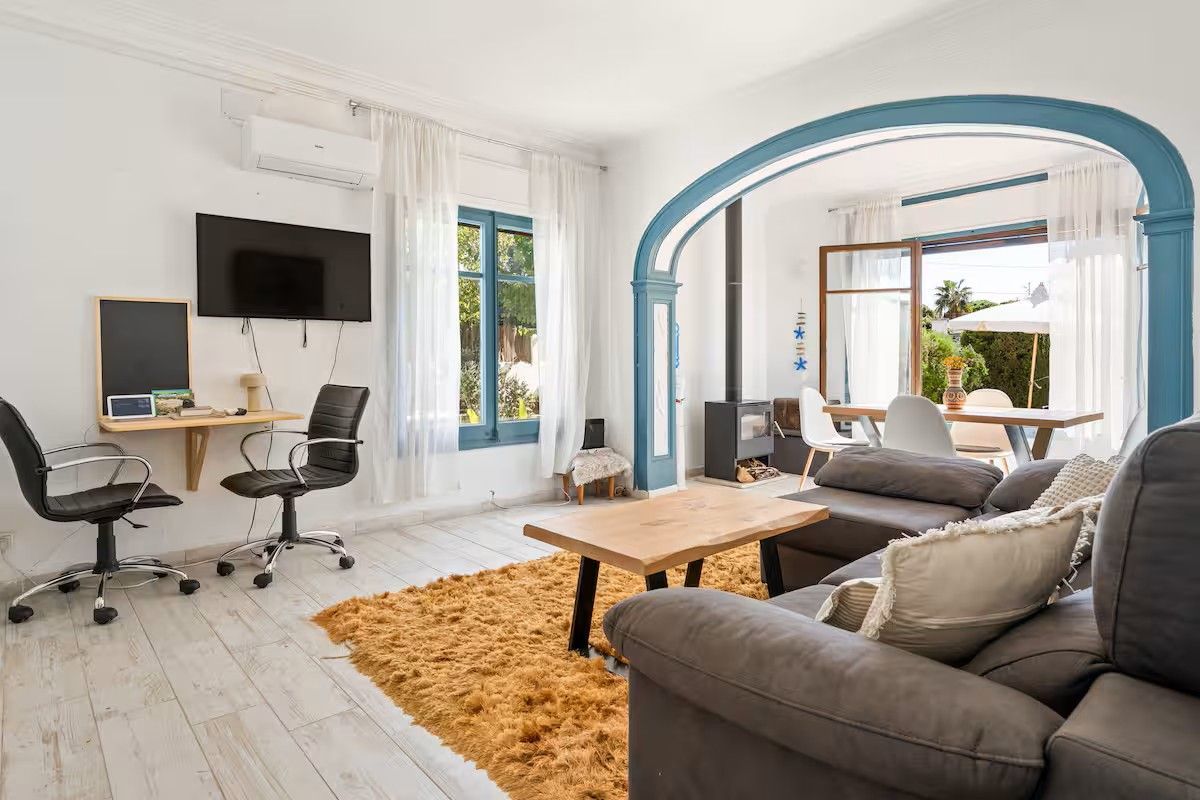 Una sala de estar con sofá, mesa y sillas.