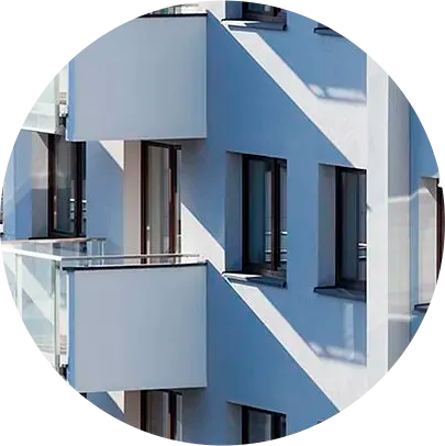Un edificio azul y blanco con balcones y ventanas en círculo.