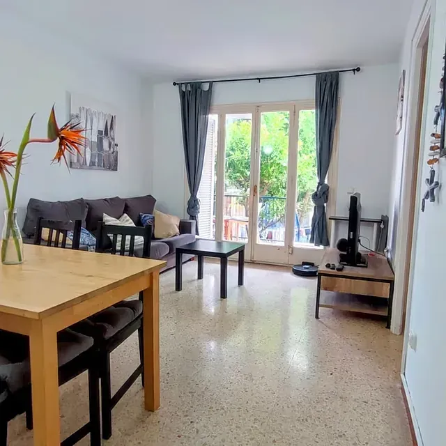 Una sala de estar con una mesa y sillas y un sofá.