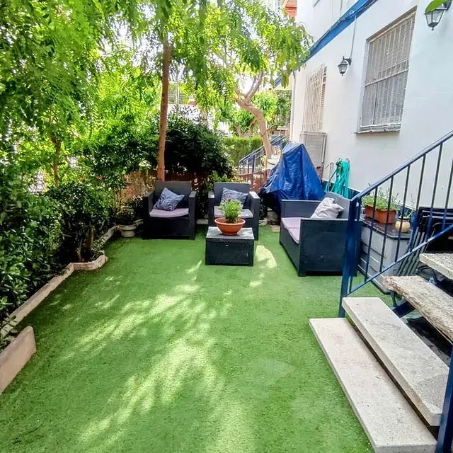 Un patio con sofá y sillas y escaleras.