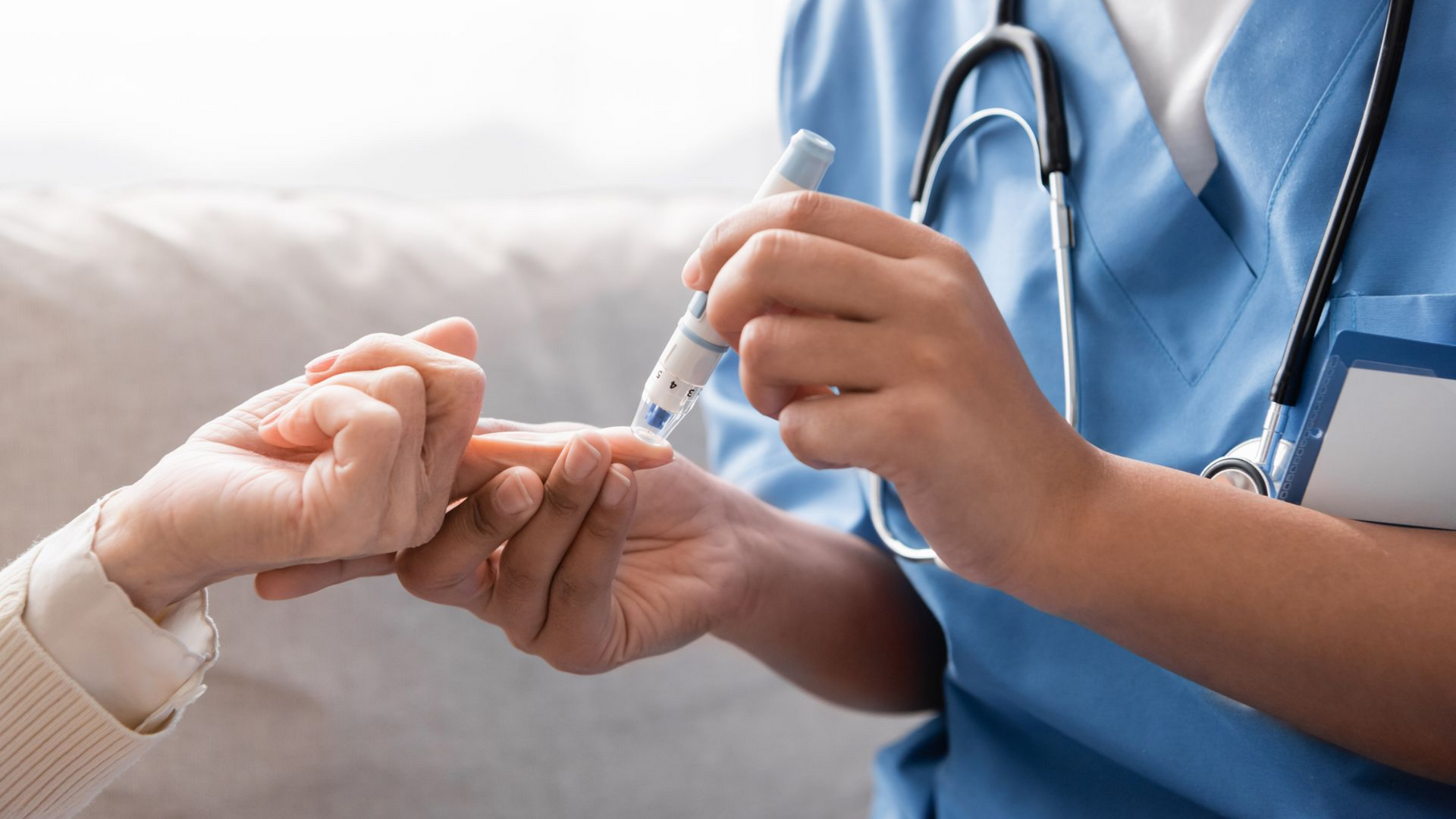 Gros plan d'une infirmière vérifiant la glycémie d'un patient à l'aide d'un lecteur de glycémie capillaire.