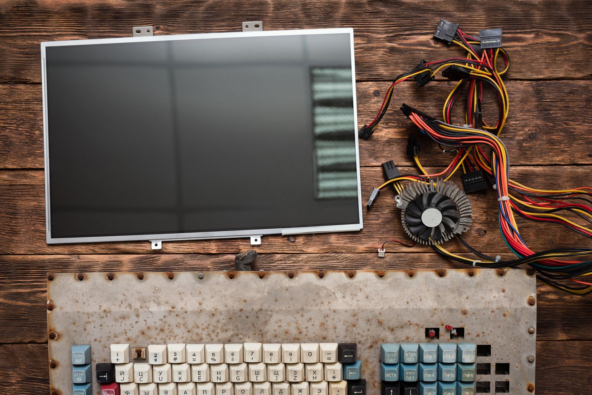 Un monitor de computadora y un teclado están sobre una mesa de madera.
