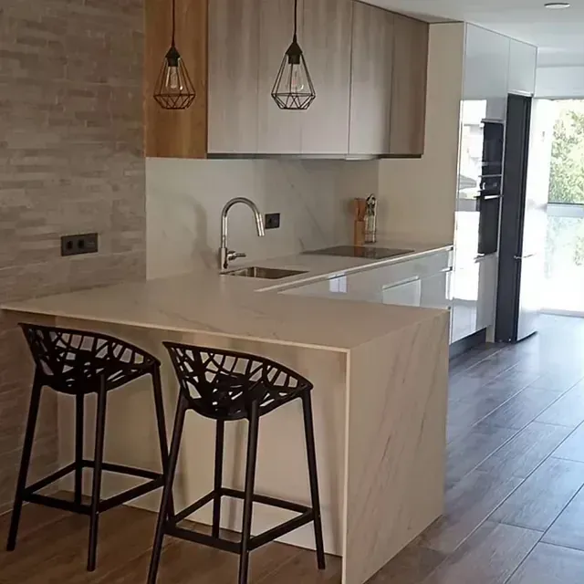 Una cocina con dos taburetes de bar y un fregadero.