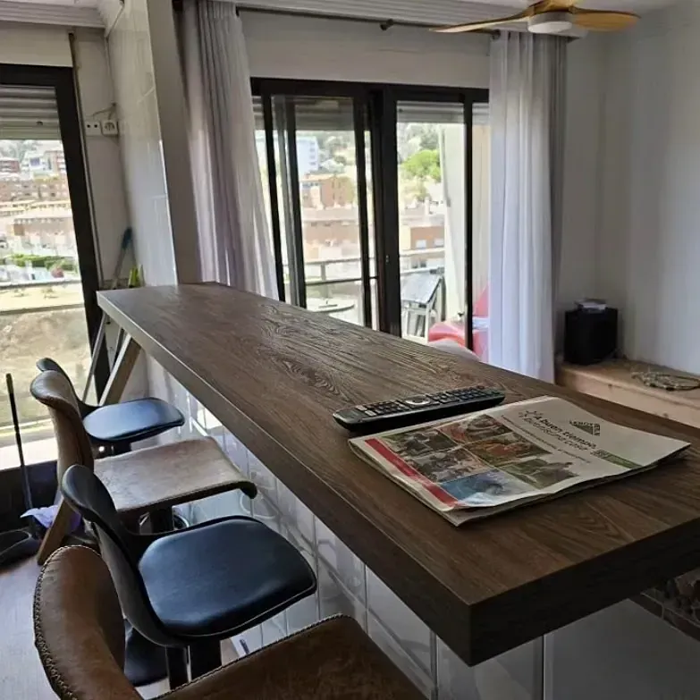 Una mesa de madera con un periódico y un control remoto sobre ella.