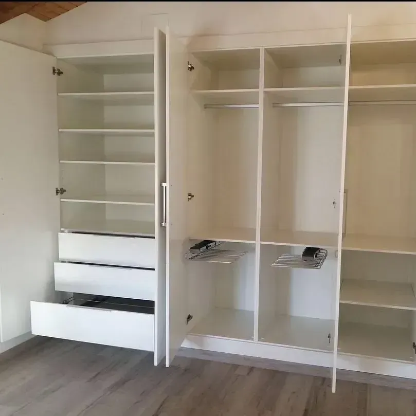 Un armario blanco con las puertas abiertas y cajones.