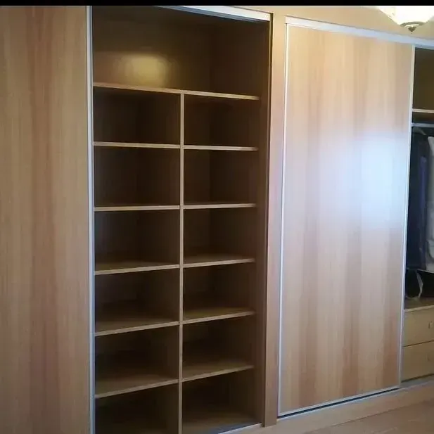 Un gran armario de madera con puertas correderas y estantes.