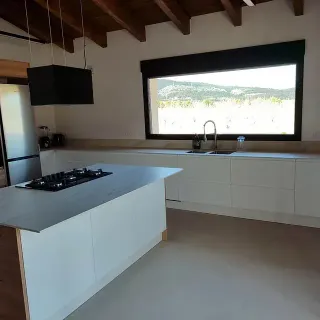 Una cocina con una gran isla y una gran ventana.