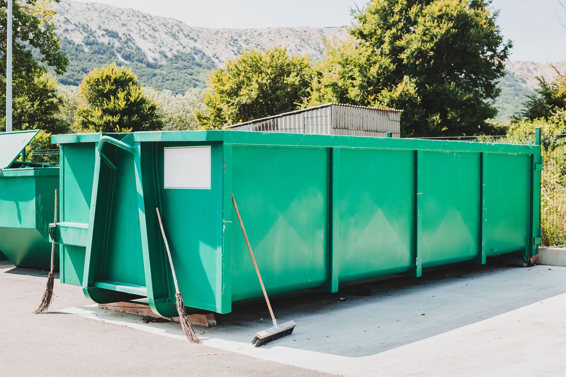 Une benne verte posée sur un site de tri de déchets.
