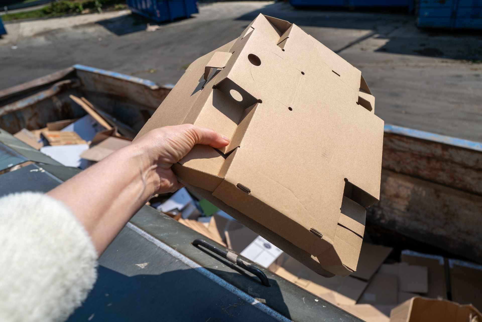 Une main féminine qui tient un carton plié.