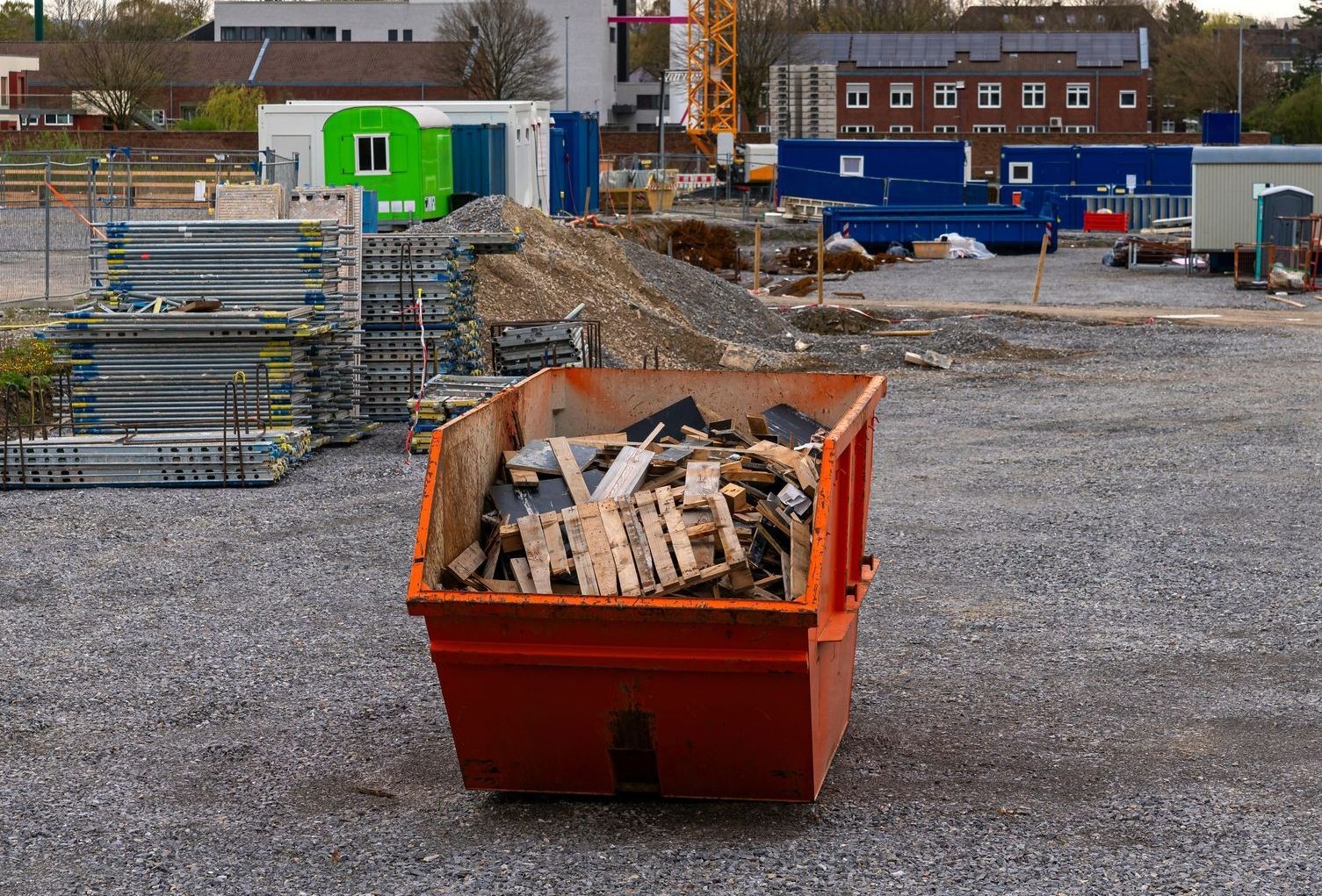 Une benne remplie de gravats posée sur un chantier.