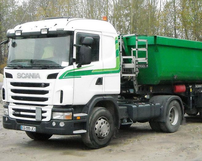 Camion-benne en train de rouler sur une route.