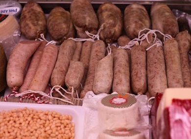 Una vitrina de carnicero llena de carnes y embutidos