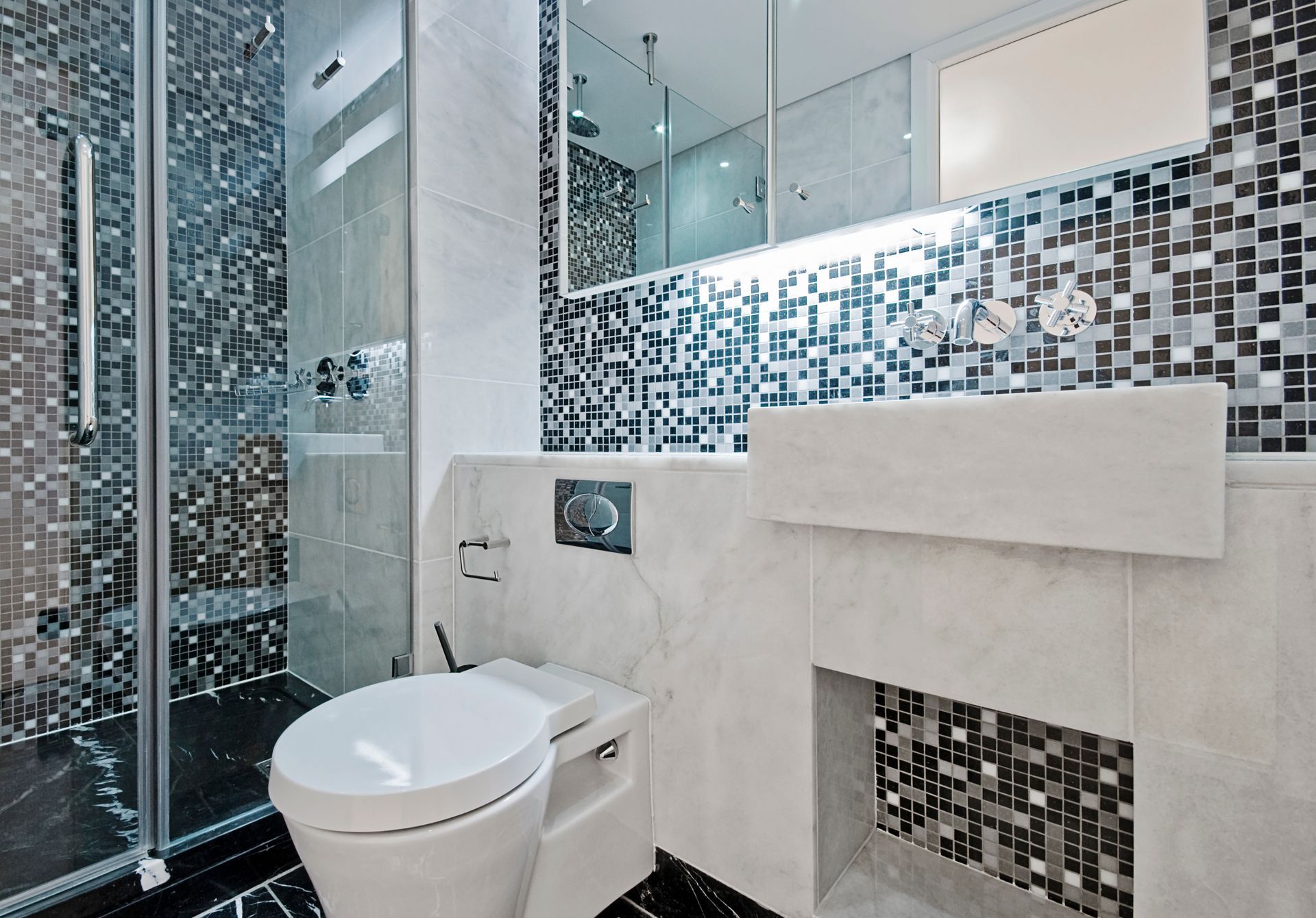 Salle de bains moderne avec douche en verre, toilettes et accents de carreaux de mosaïque.