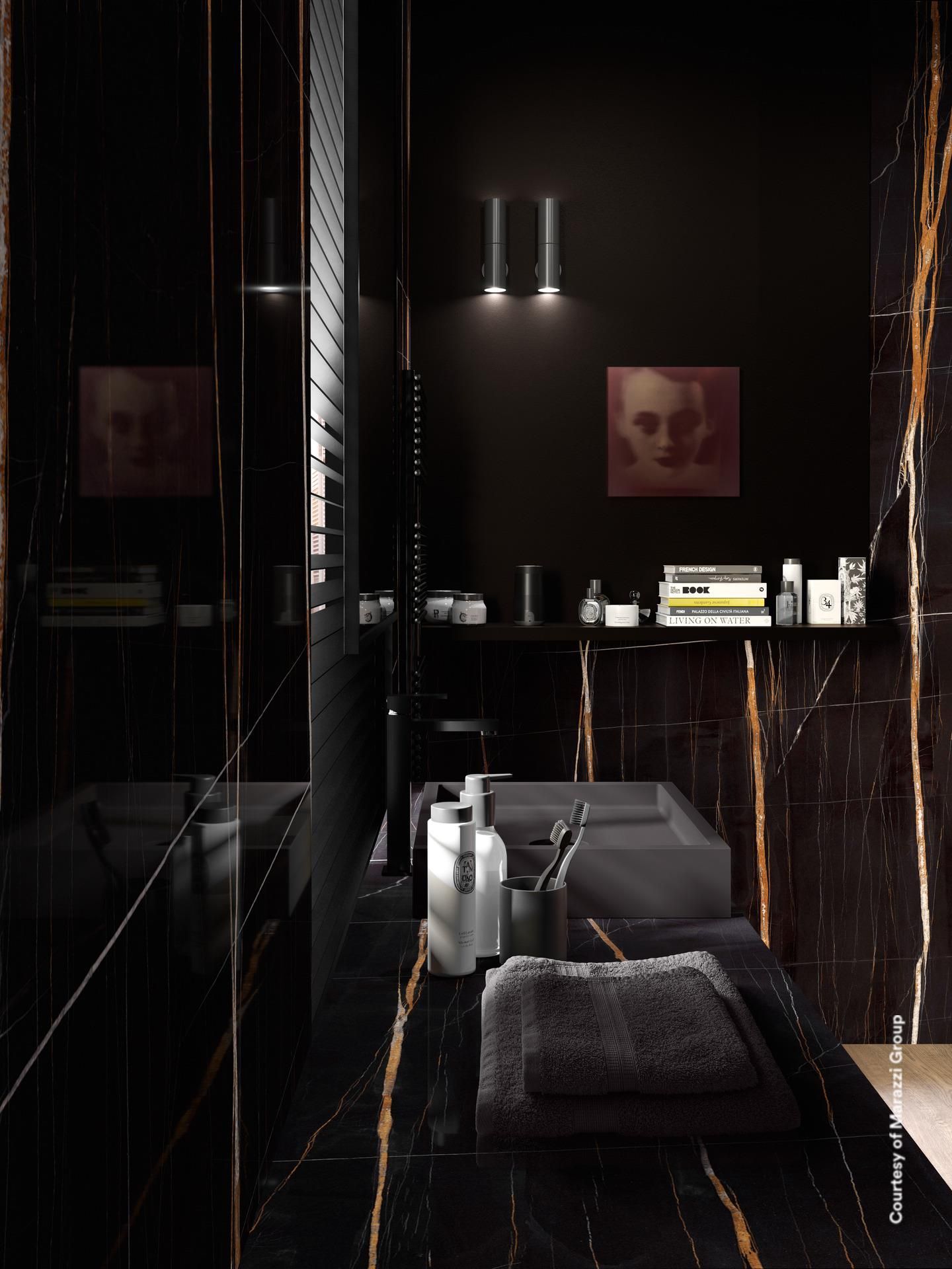 Salle de bain en marbre noir avec veines dorées, luminaires noirs et serviettes.