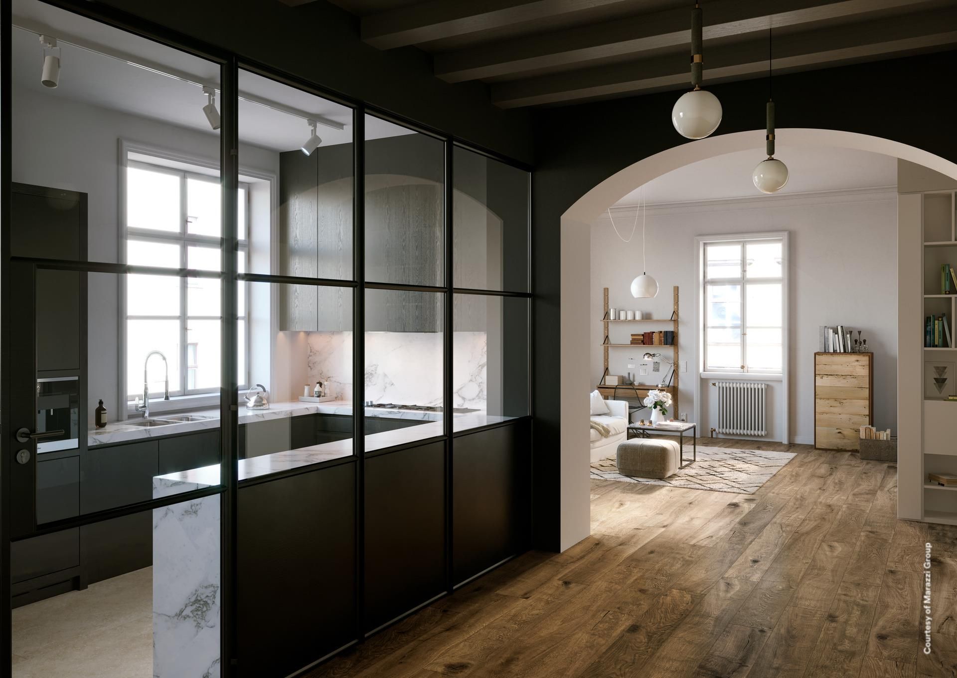 Cuisine moderne avec paroi vitrée, donnant sur un séjour avec parquet.