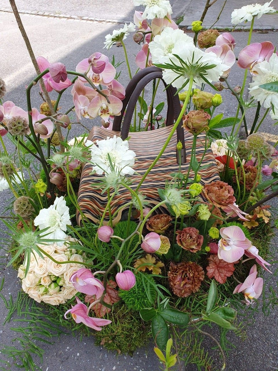 Auf dem Boden steht ein mit Blumen gefüllter Korb.