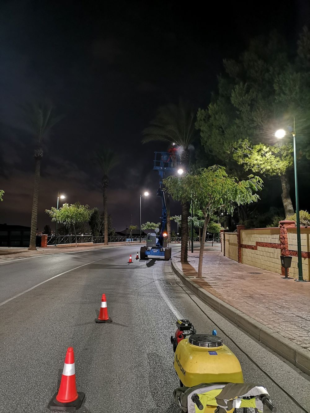 Un vehículo amarillo está estacionado al costado de una calle por la noche.