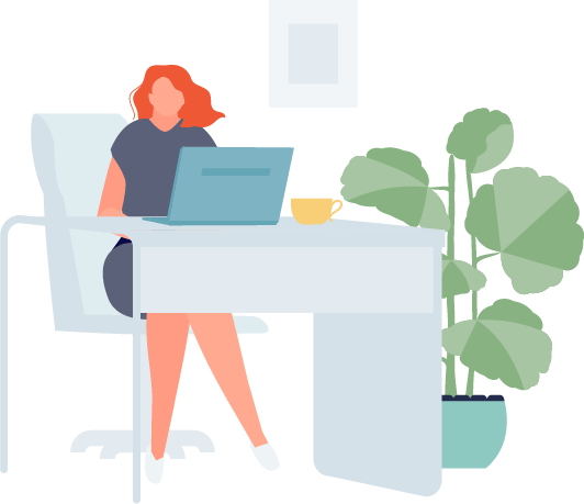 Eine rothaarige Frau arbeitet an einem Laptop an einem Schreibtisch, neben dem eine Pflanze und eine Tasse stehen.