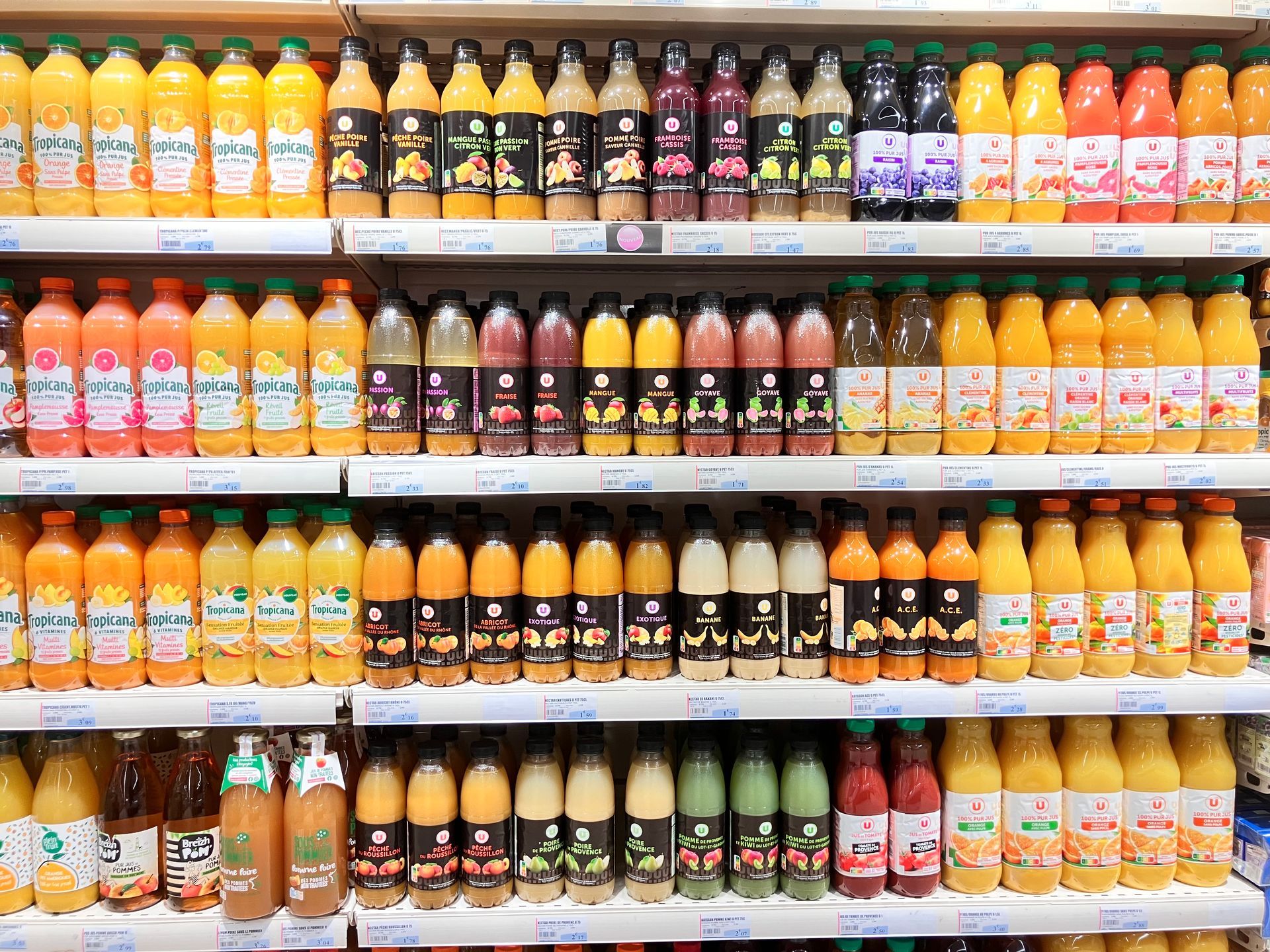 Intérieur du supermarché avec des étals de fruits et légumes et des rayons de produits