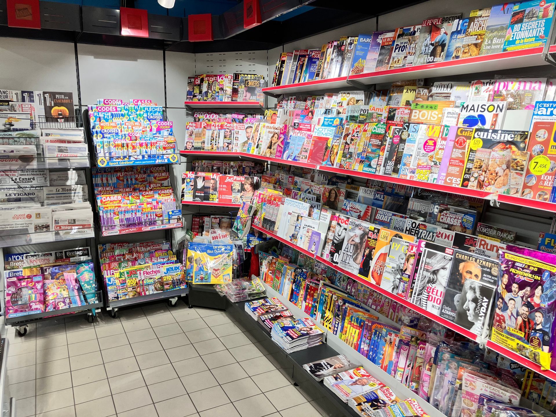 Espace presse du supermarché avec des magazines et des journeaux