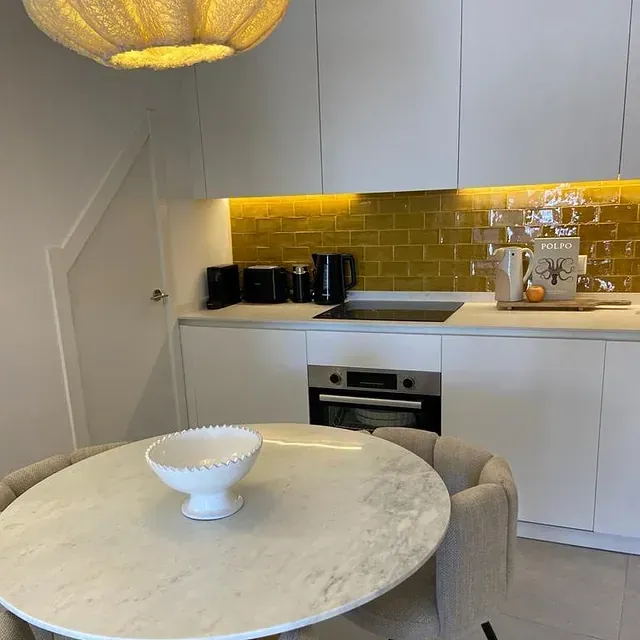 Una cocina con una mesa y sillas y un cuenco sobre la mesa.