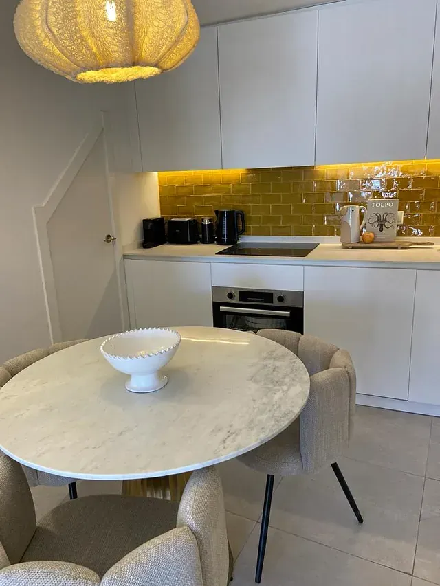 Una cocina con una mesa y sillas y un cuenco sobre la mesa.