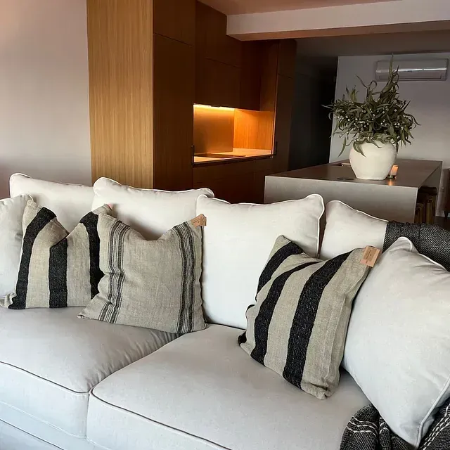 Un sofá blanco con almohadas a rayas.