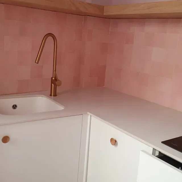 Una cocina con fregadero y grifo de cobre