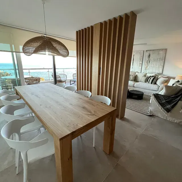 Una sala de estar con una mesa y sillas de madera.