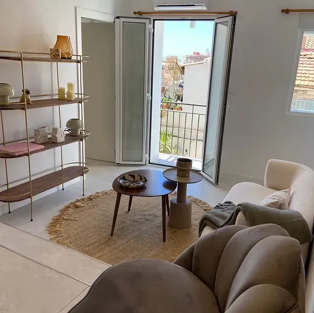 Una sala de estar con un sofá, una mesa de café y estantes.