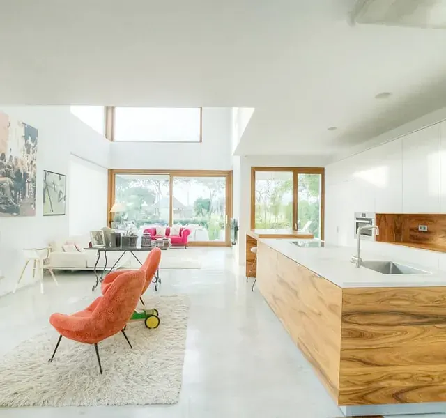 Una sala de estar con un sofá y sillas y una cocina.