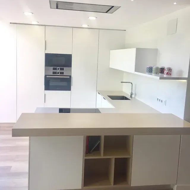 Una cocina con gabinetes blancos y un horno de estufa.