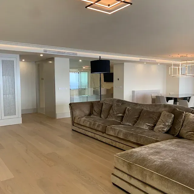 Una sala de estar con un sofá y una lámpara.