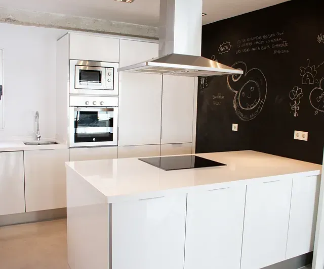 Una cocina con gabinetes blancos y un horno de estufa.